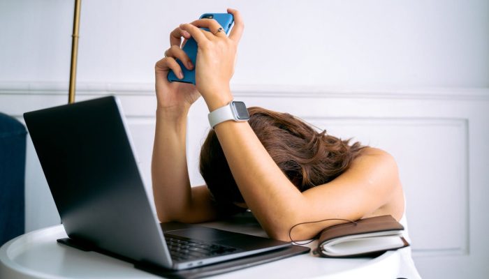 A Woman Wearing a Smartwatch Holding a Smartphone